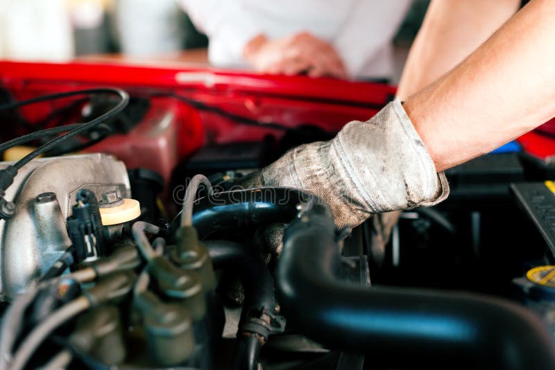 Meccanico d'auto, nel suo negozio di riparazione in piedi accanto alla macchina close-up del motore.