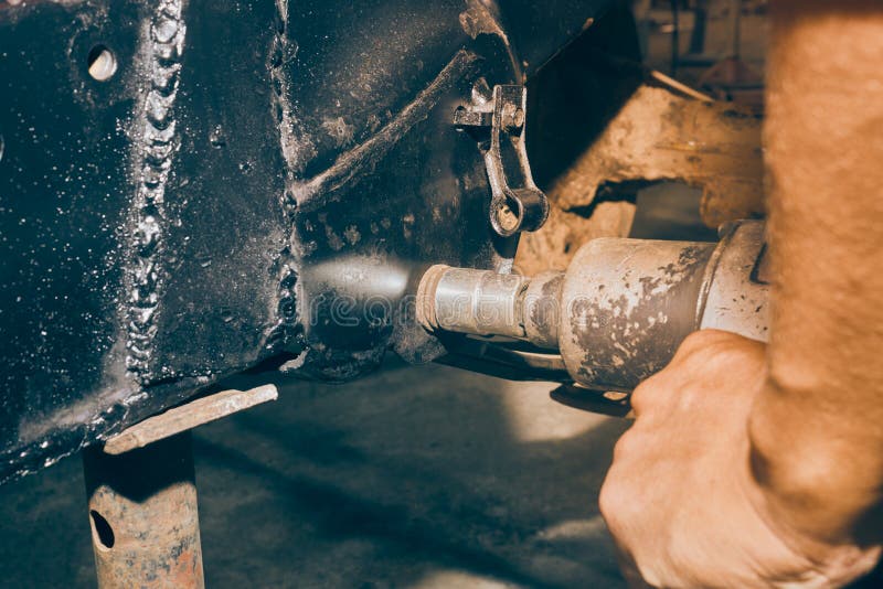 Car Mechanic Tighten Nut of Car Leaf Spring by Wind Block in Vintage