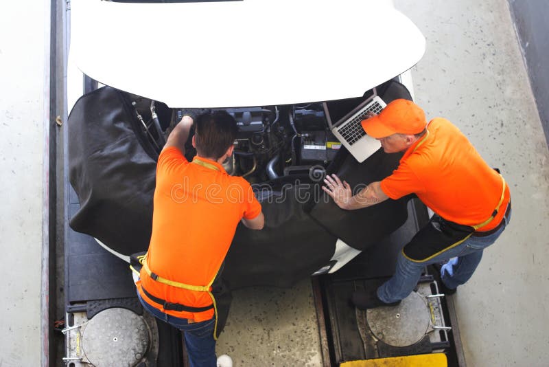 Car mechanic use notebook computers to check engine and service maintenance of industrial to engine repair, for transport automobi royalty free stock photo