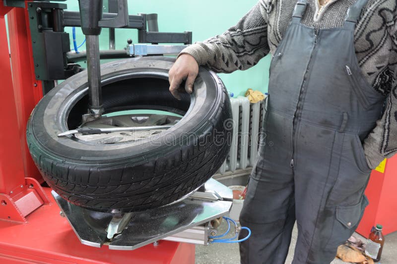 The car mechanician changes a tyre cover