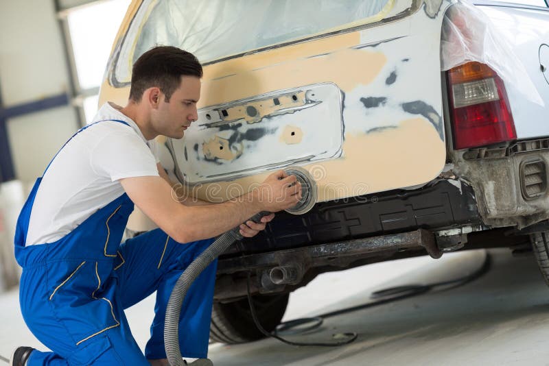 Car painter polishes body part stock photography