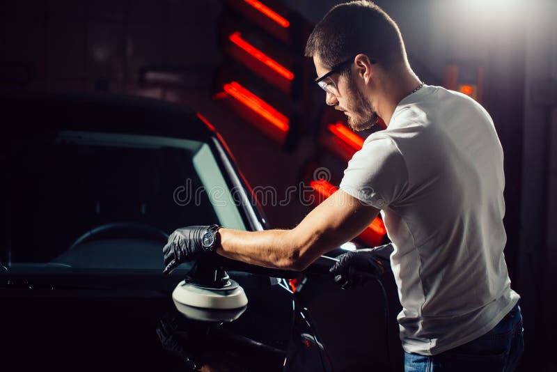 Car polish wax. worker hands holding a polisher