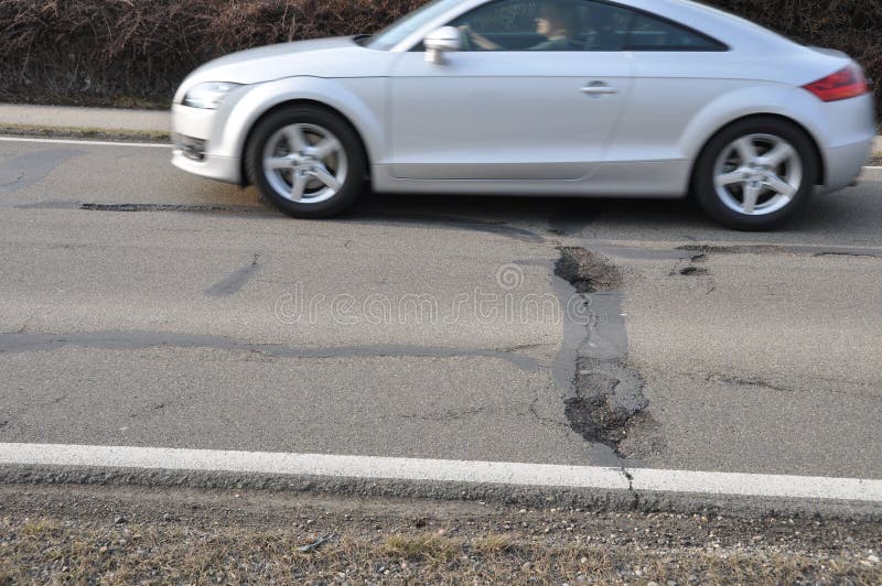 Car and pothole on road