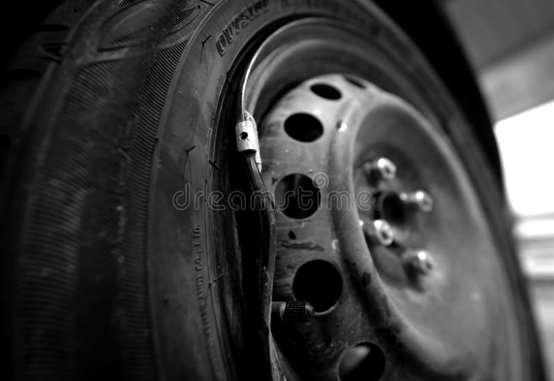 Car with a Punctured and Broken Wheel in a Car Repair Shop Stock Photo