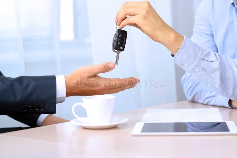 Car salesman handing over the keys for a new car to a young businessman royalty free stock photos Car salesman handing over the keys for a new car to a young businessman royalty free stock photos
