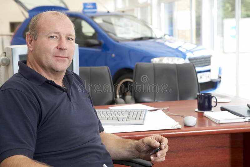 Car salesman sitting in showroom stock image Car salesman sitting in showroom stock image