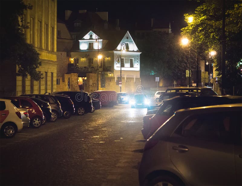 Car searching free parking space at night in city or town center. Vehicle trying to find place to park and stop. stock photo Car searching free parking space at night in city or town center. Vehicle trying to find place to park and stop. stock photo