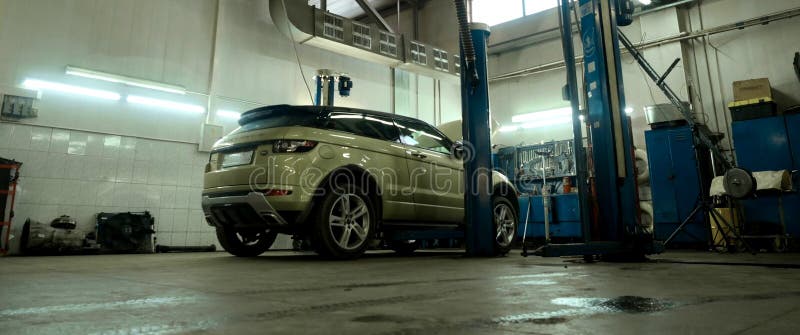 Car service center. Vehicle raised on lift at maintenance station. Auomobile repair and check up. royalty free stock photography Car service center. Vehicle raised on lift at maintenance station. Auomobile repair and check up. royalty free stock photography