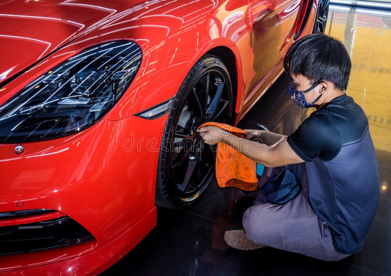 Car Service Worker Polishing Car Wheels with Microfiber Cloth. Stock