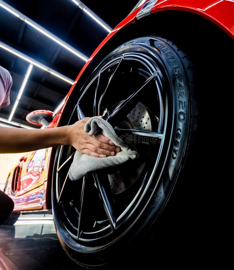 Car Service Worker Polishing Car Wheels with Microfiber Cloth. Stock