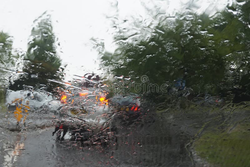 Car Tail Lights through a Rain Covered Windshield, Focus on Rain Drops