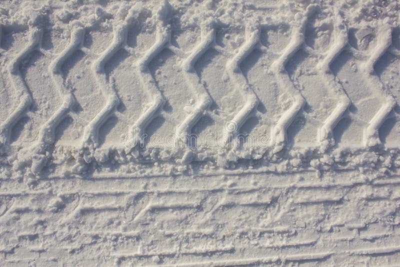 Car Tire Prints on White Snow Closeup. Rough Surface Texture Stock