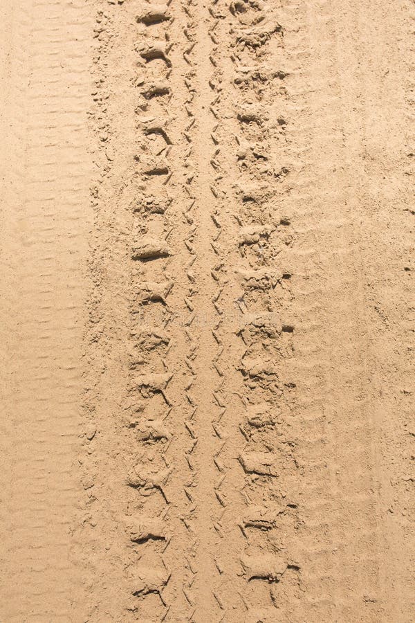 Car tire tracks on the yellow sand