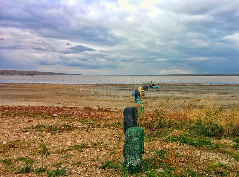 Car tires on lake shore stock image. Image of tires, herbs 79955737