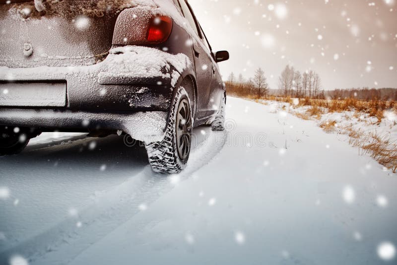 Car tires on winter road covered with snow