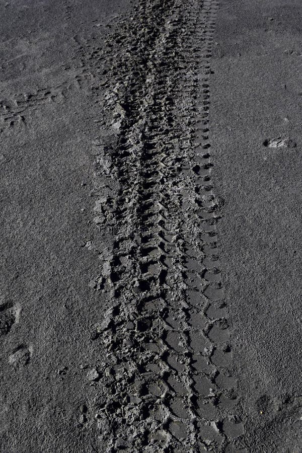 The car tracks on the ground. Tyre track on dirt sand or mud