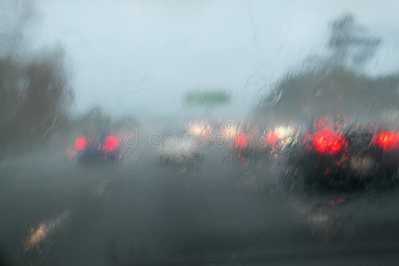 Car traffic driving with heavy rain on car windscreen - State Hi