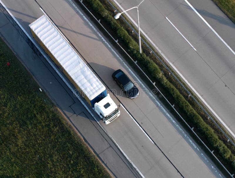 Un'auto e un camion di guida accanto all'altro, su una strada.