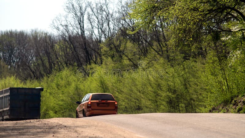 A car and a truck on a slope on a forest road. Back view. stock photography