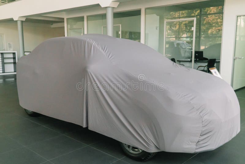 The Car Under the Protective Cover is in the Showroom Stock Image