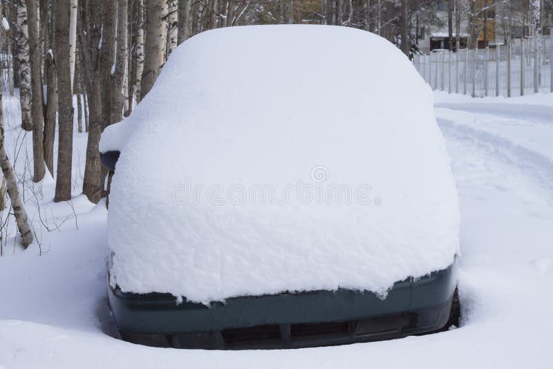 A car under the snow against the background of trees royalty free stock photo