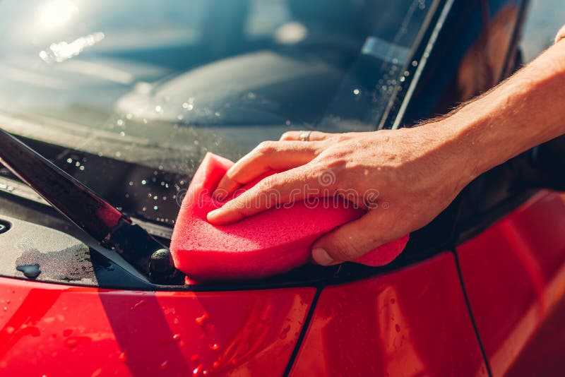 Car Washing. Man Cleaning Car with Soapy Sponge Outdoors. Closeup