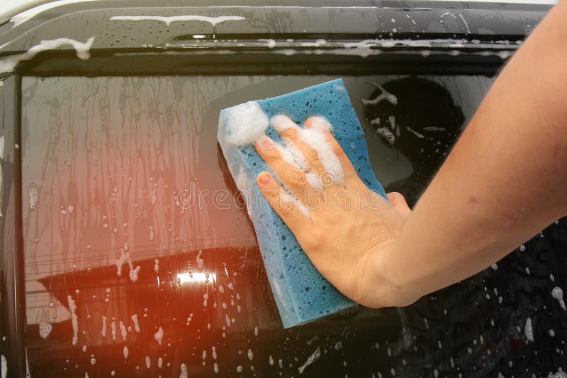 Car Washing by Using Sponge and Cleaner at Glass Door Stock Image