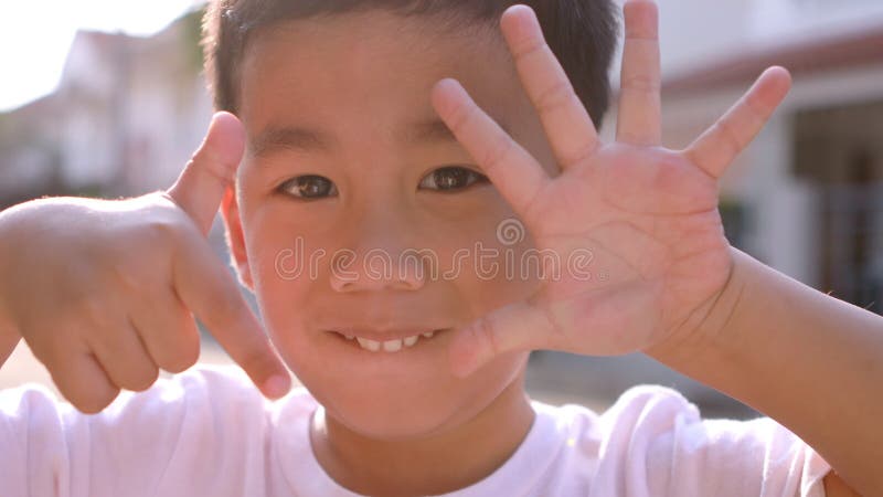 A cara ascendente próxima de crianças asiáticas alegres entrega o jogo do número um dez