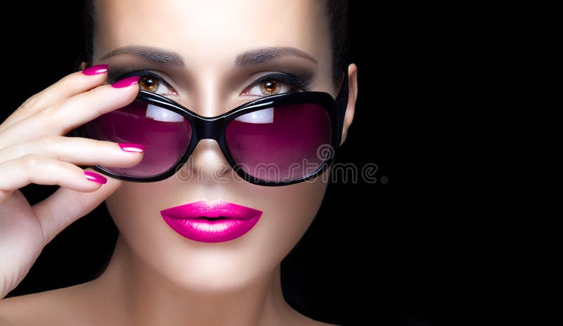 Cara de la mujer del primer en gafas de sol de gran tamaño rosadas Maquillaje y Mani fotos de archivo libres de regalías Cara de la mujer del primer en gafas de sol de gran tamaño rosadas Maquillaje y Mani fotos de archivo libres de regalías