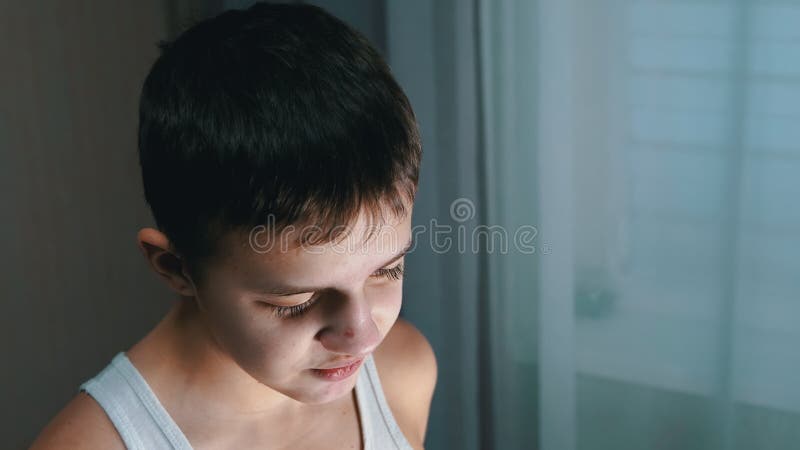 Cara de un adolescente sonriente culpable que habla y que tiene una mirada negativa. vista lateral 4k