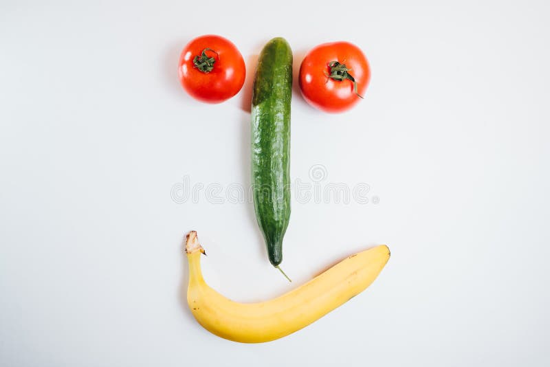 Cara feliz hecha con las frutas frescas Tomate, pepino, plátano foto de archivo Cara feliz hecha con las frutas frescas Tomate, pepino, plátano foto de archivo