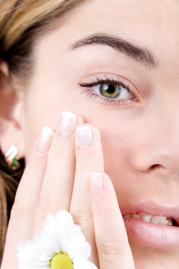 Young face with green eyes and nails french close-up with daisy. Young face with green eyes and nails french close-up with daisy