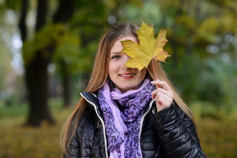 Cara hermosa de la mujer joven con una hoja fotos de archivo libres de regalías Cara hermosa de la mujer joven con una hoja fotos de archivo libres de regalías