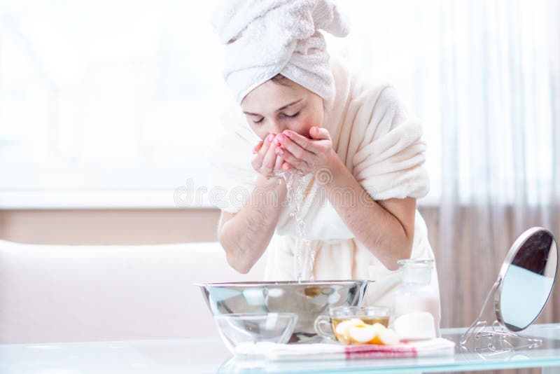 Cara hermosa del lavado de la mujer joven con agua por la mañana Concepto de higiene y de cuidado para la piel en casa fotografía de archivo Cara hermosa del lavado de la mujer joven con agua por la mañana Concepto de higiene y de cuidado para la piel en casa fotografía de archivo
