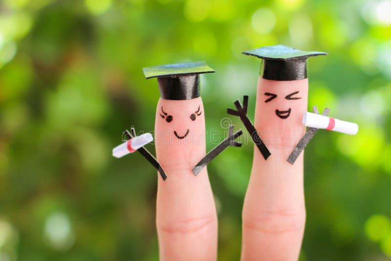 Cara pintada nos dedos estudantes que guardam seu diploma após a graduação fotografia de stock Cara pintada nos dedos estudantes que guardam seu diploma após a graduação fotografia de stock