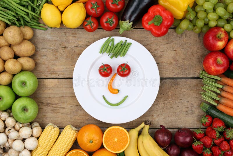 Cara sonriente de la consumición sana de verduras en la placa fotografía de archivo libre de regalías Cara sonriente de la consumición sana de verduras en la placa fotografía de archivo libre de regalías