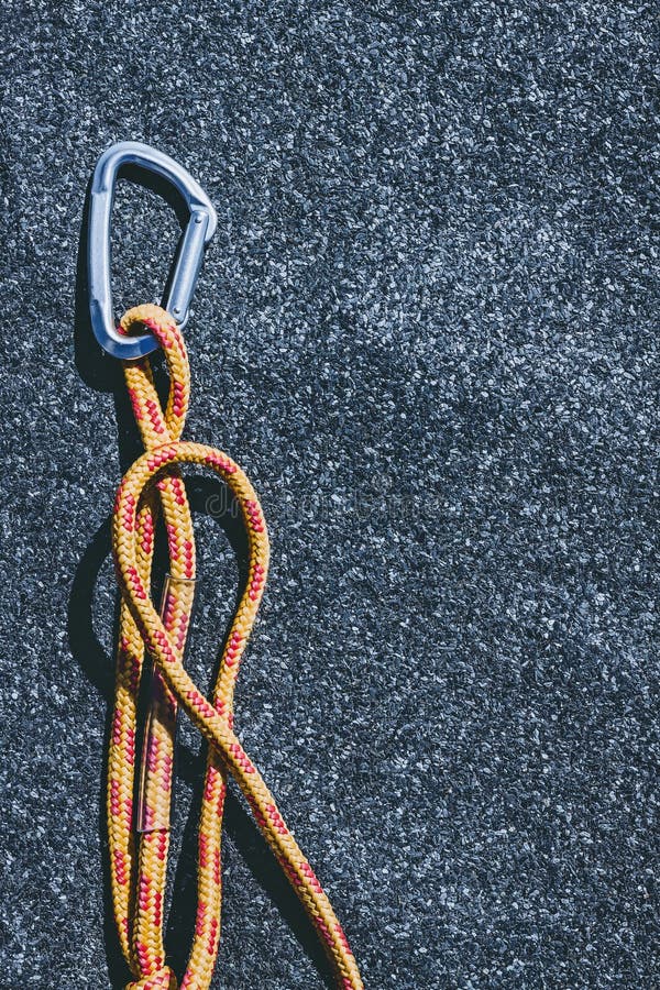 Carabiner met heldere oranje kabel op a texured dakwerk gevoelde oppervlakte met vele kleine grijze stenen stock afbeelding Carabiner met heldere oranje kabel op a texured dakwerk gevoelde oppervlakte met vele kleine grijze stenen stock afbeelding