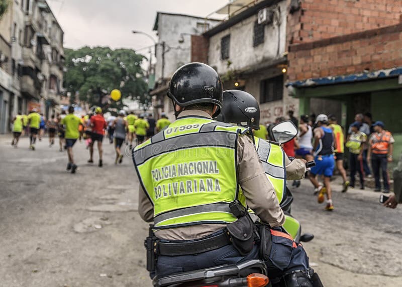 Caracas, Venezuela - 24 de abril de 2016: Policie tomar dos corredores de maratona na maratona 42K de CAF