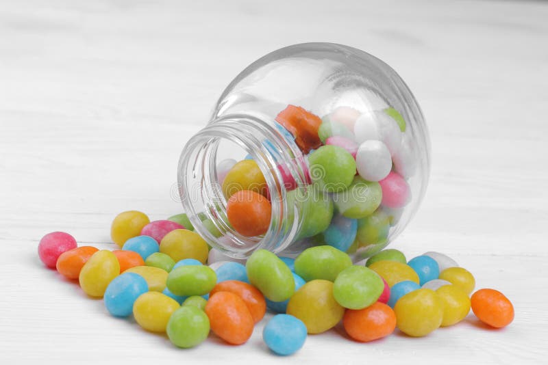 Caramella rotonda multicolore in un barattolo di vetro su un fondo bianco immagine stock libera da diritti Caramella rotonda multicolore in un barattolo di vetro su un fondo bianco immagine stock libera da diritti