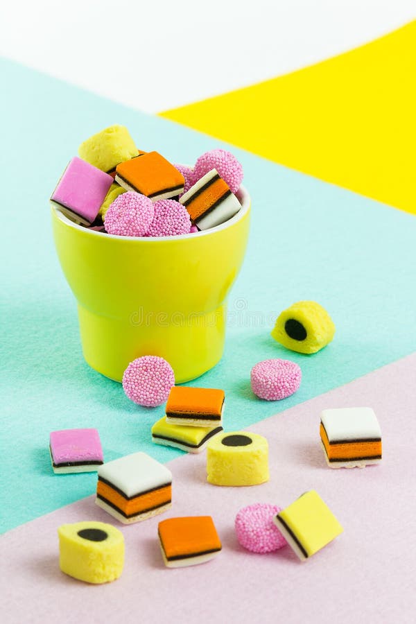Caramelo de la comida de la moda: regaliz allsorts en una taza amarilla foto de archivo Caramelo de la comida de la moda: regaliz allsorts en una taza amarilla foto de archivo
