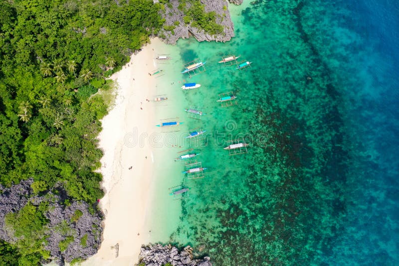 Caramoan Islands, Matukad, Philippines. Boats and tourists on the beach