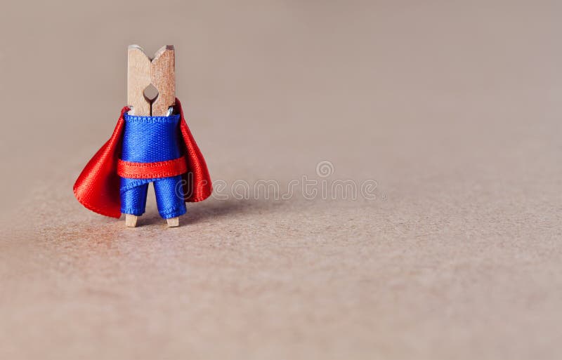 Carattere coraggioso del supereroe della molletta da bucato sul fondo marrone della carta del mestiere vestito blu e giocattolo r immagini stock libere da diritti Carattere coraggioso del supereroe della molletta da bucato sul fondo marrone della carta del mestiere vestito blu e giocattolo r immagini stock libere da diritti