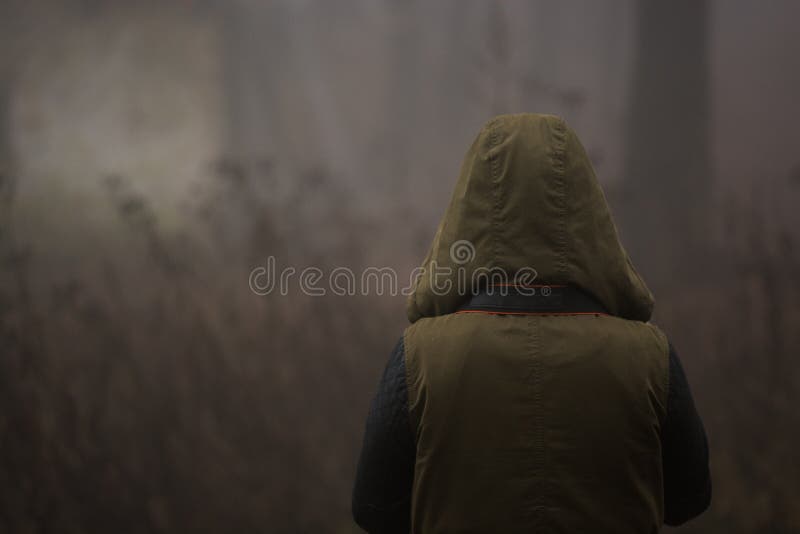 Carattere incappucciato circondato da nebbia fotografie stock Carattere incappucciato circondato da nebbia fotografie stock