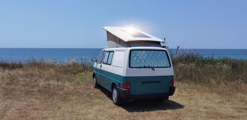 Caravan car solar panels electricity  by the sea in summer beach trees blue sky  travel