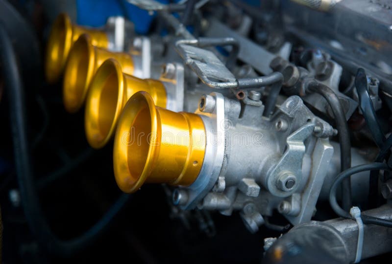 Air inlets of carburettors on classic four cylinder racing car engine. Shallow depth of field with the nearest intake in focus. Air inlets of carburettors on classic four cylinder racing car engine. Shallow depth of field with the nearest intake in focus.