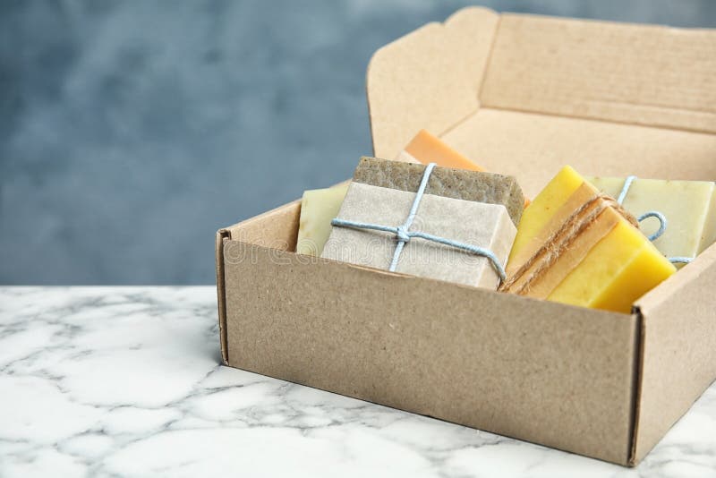 Cardboard Box with Different Handmade Soap Bars on Table Stock Image