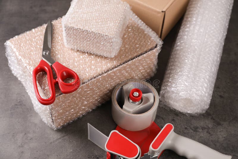 Cardboard Box Packed In Bubble Wrap Scissors And Adhesive Tape On White  Background Stock Photo - Download Image Now - iStock