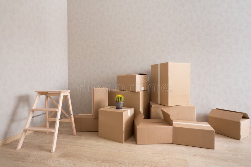 Cardboard boxes pile in new empty room with step-ladder