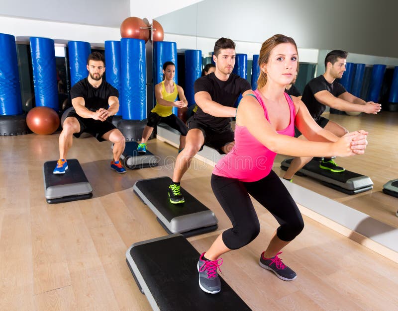 Cardio step dance squat group at fitness gym royalty free stock photo