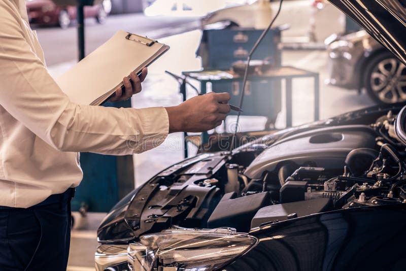 This career man saleman business inspection writing note on notepad or book, paper with car blurry background.for transport stock photo This career man saleman business inspection writing note on notepad or book, paper with car blurry background.for transport stock photo
